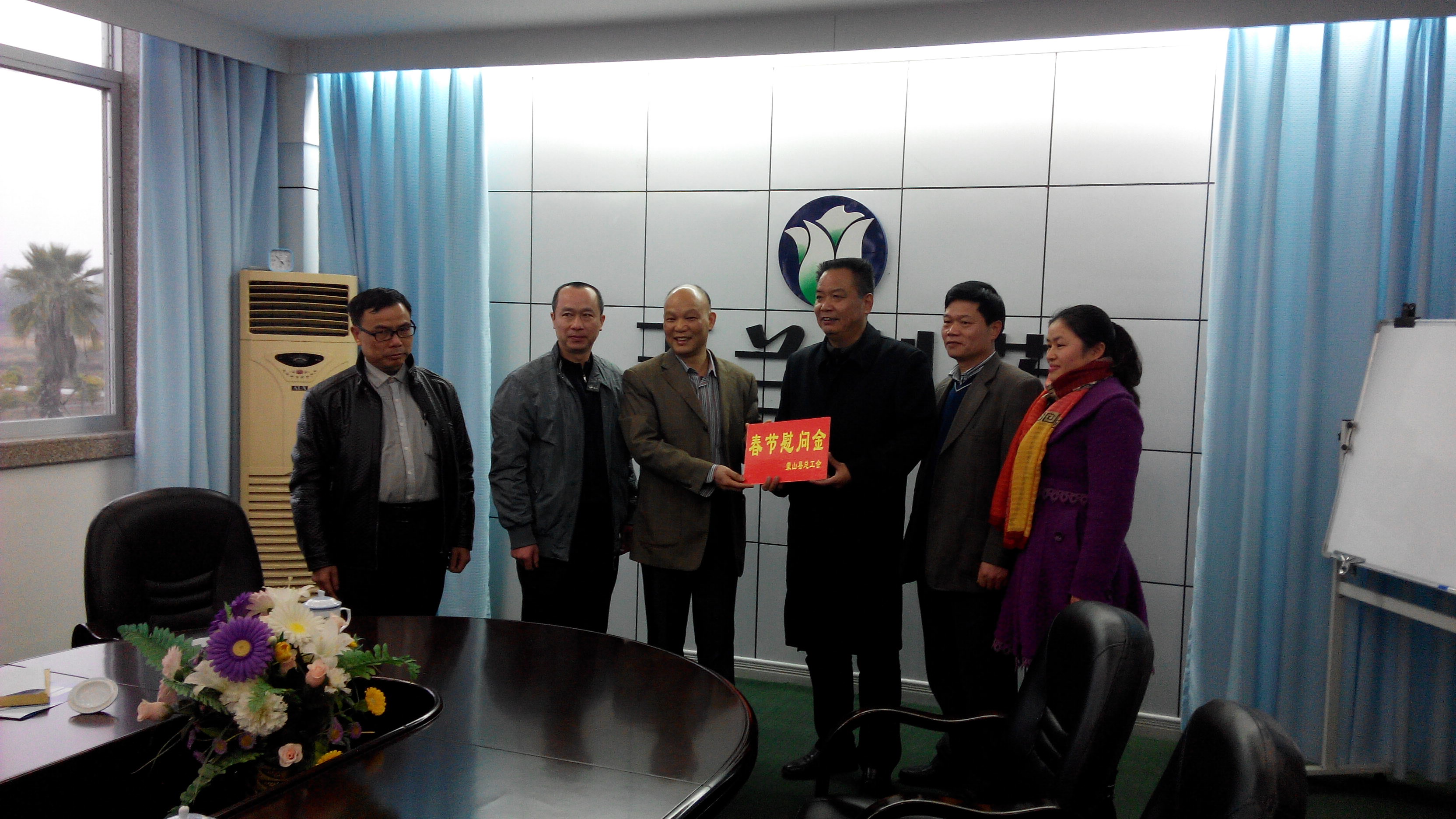 1月28日，梧州市總工會副主席謝海益帶隊到蒙山開展春節(jié)前慰問活動。圖為市總工會謝副主席給玉蘭制藥公司送上春節(jié)慰問金。--